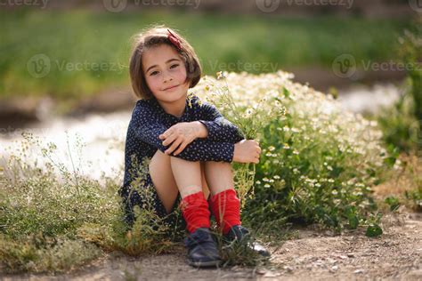 Little girl sitting in nature field wearing beautiful dress 4521116 Stock Photo at Vecteezy