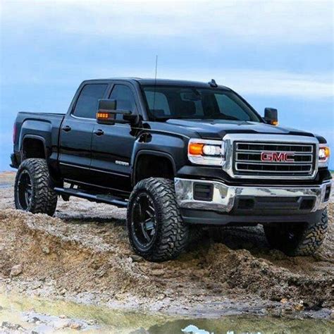 a black truck parked on top of a rocky hill