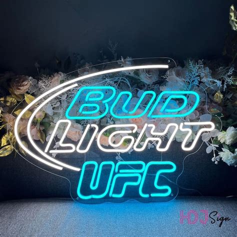 a neon sign that says bud light up with flowers in the back ground ...