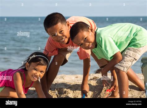 Happy kids playing on the beach Stock Photo - Alamy