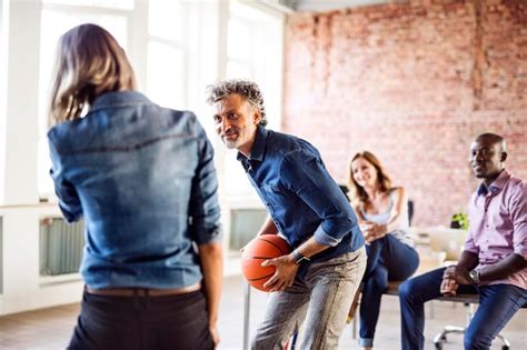 Premium Photo | Colleagues playing basketball in office