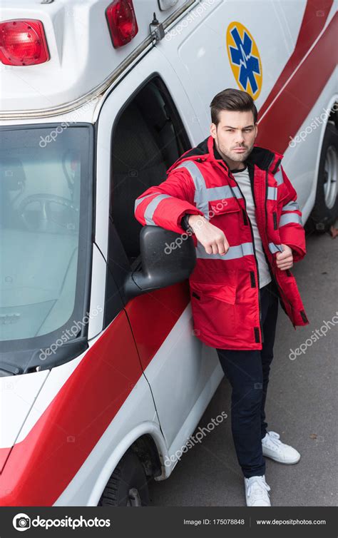 Serious Young Male Paramedic Standing Leaning Ambulance — Stock Photo © ArturVerkhovetskiy ...