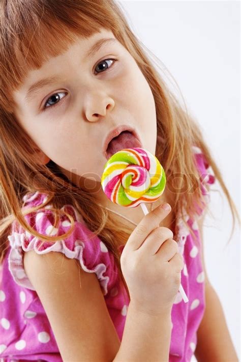 Portrait of funny child eating sweet candy | Stock Photo | Colourbox