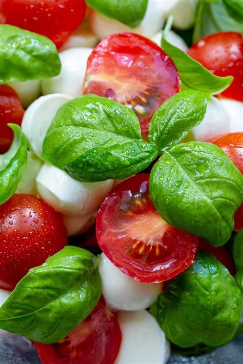 Delicious italian caprese salad with ripe tomatoes, fresh garden basil and mozzarella cheese ...