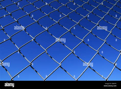 chain link fence mesh with blue sky background Stock Photo - Alamy