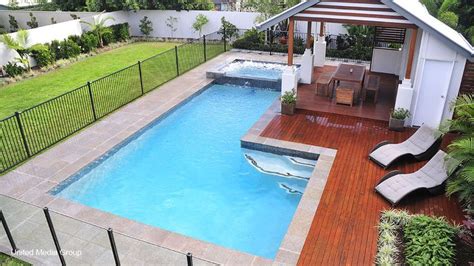 L-shaped pool and spa with timber decking and a pergola. Photo courtesy of Performance Pool ...