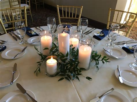 Ruscus greenery centerpiece with assorted pillar candles | Greenery centerpiece, Candle wedding ...