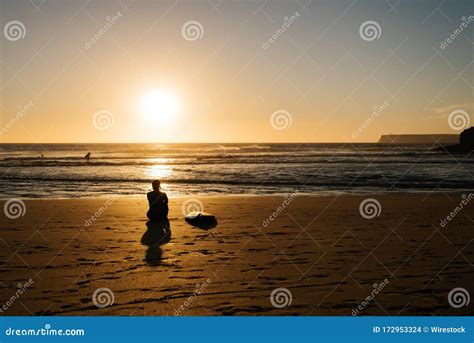 Silhouette of a Person Sitting on the Beach Shore Looking at the Sea ...