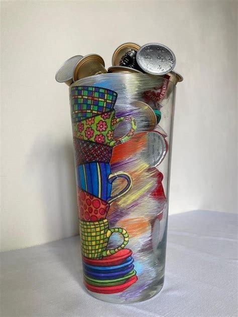 a tall glass with some colorful designs on the bottom and sides, sitting on a white surface