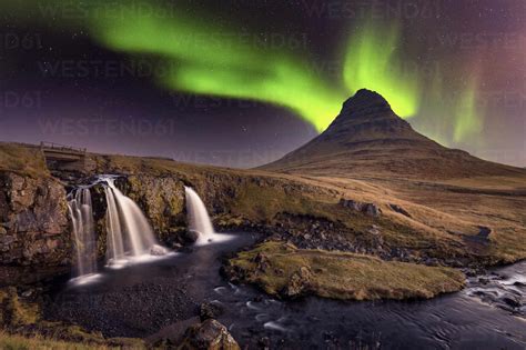 Aurora Borealis (Northern Lights) over Kirkjufell Mountian with a small waterfall in Iceland ...