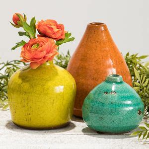 three different colored vases with flowers in them