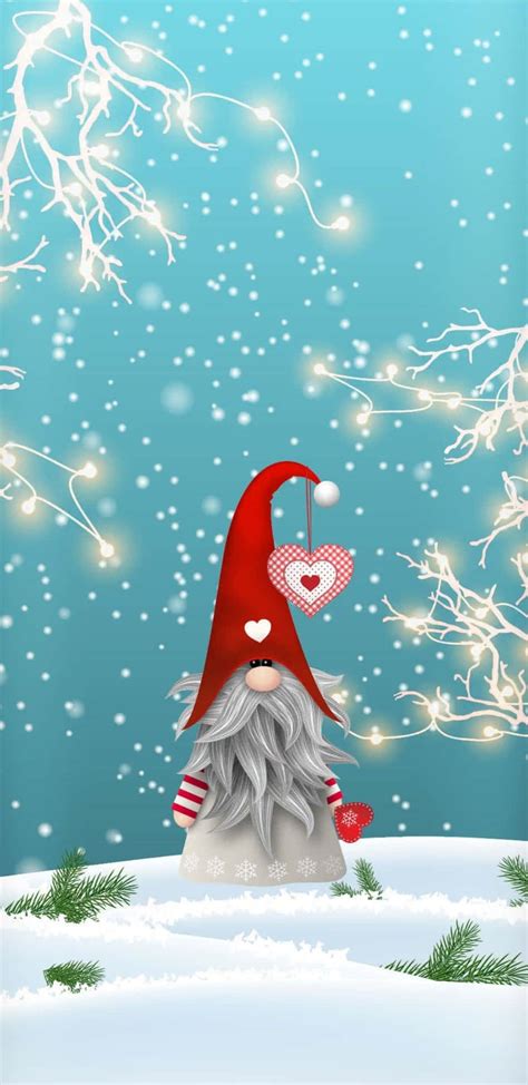 Download Joyful Christmas gnome sitting in the snow Wallpaper | Wallpapers.com