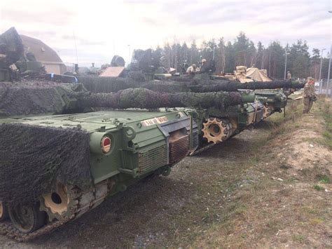 M1A2 Abrams tanks covered with camouflage nets from the composition of ...