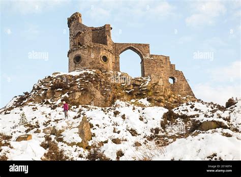 Mow Cop castle, the folly of a ruined castle in snow during winter, standing on the Gritstone ...