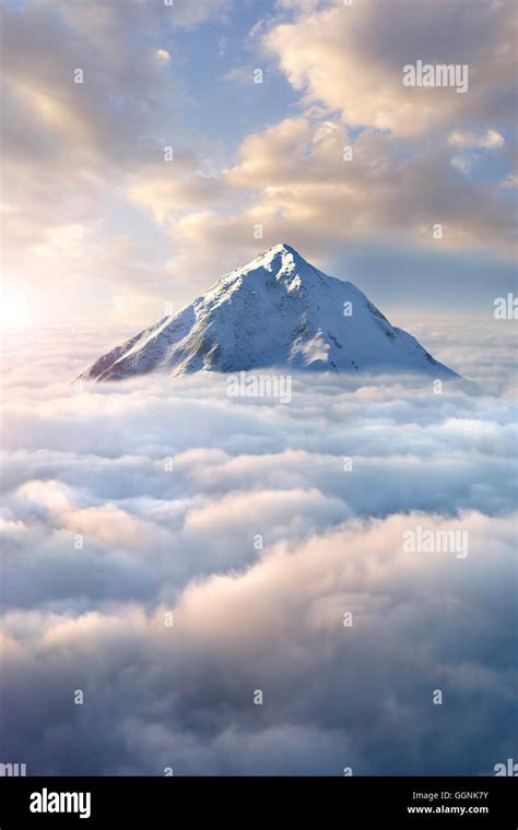 Snow-covered mountaintop above clouds Stock Photo - Alamy