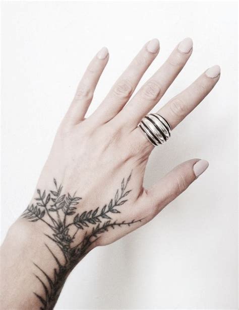 Black greenery inked on the hand - Tattoogrid.net