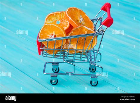 Dry orange with shopping cart on blue wooden kitchen table background Stock Photo - Alamy