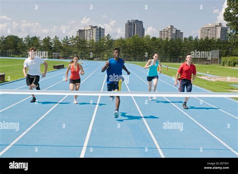 Runners on a race track at finish line Stock Photo - Alamy