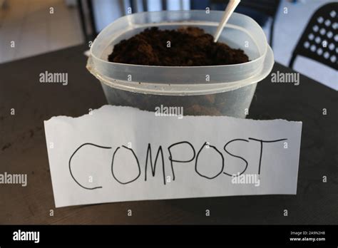 Photo of a container of used coffee grounds with a sign that says compost Stock Photo - Alamy