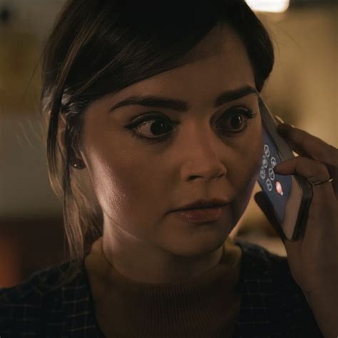 a woman holding a cell phone to her ear and looking at the camera with ...