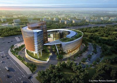 an aerial view of a circular building in the middle of a city with trees and buildings around it