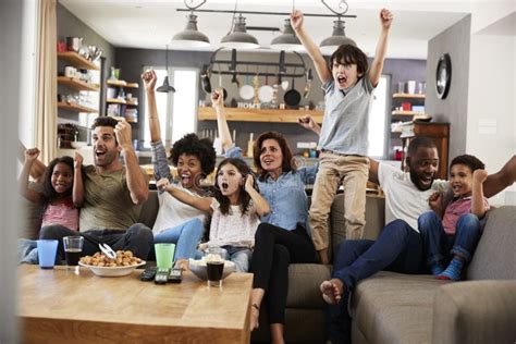 Two Families Watching Sports on Television and Cheering Stock Photo - Image of male, room: 99964186