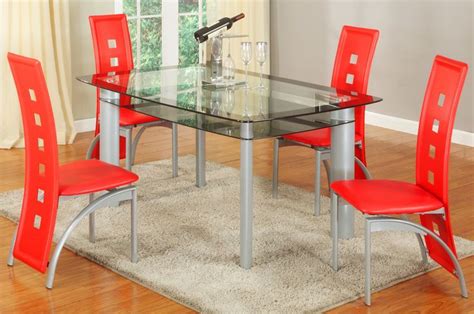 a glass dining table with red chairs around it