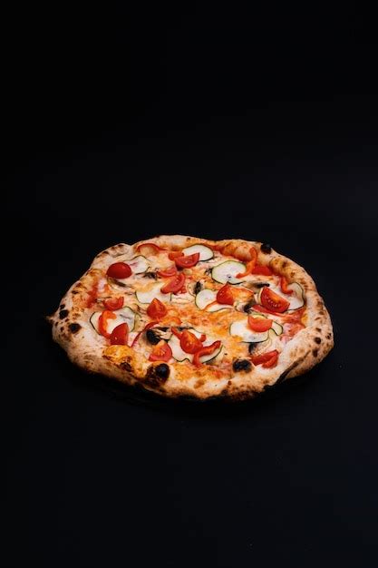 Premium Photo | Closeup shot of a tasty looking pizza isolated on a black background