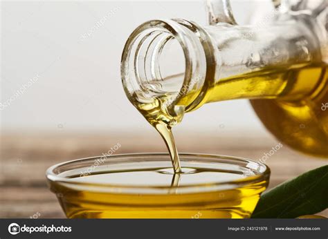 Pouring Olive Oil Bottle Glass Bowl Grey Background Stock Photo by ©AntonMatyukha 243121978