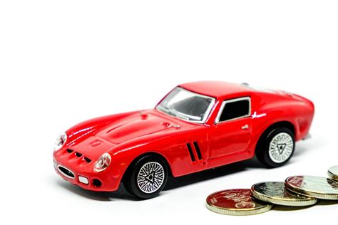 Red toy car with coins on white background - Creative Commons Bilder