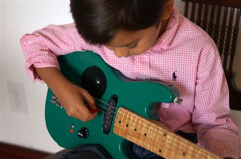 kid-playing-electric-guitar – Children in Homes Music Lessons