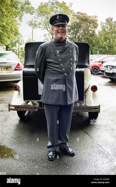 A chauffeur in uniform in front of faux-vintage car Stock Photo - Alamy