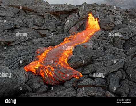 Hot magma of an active lava flow emerges from a fissure, the heat of ...