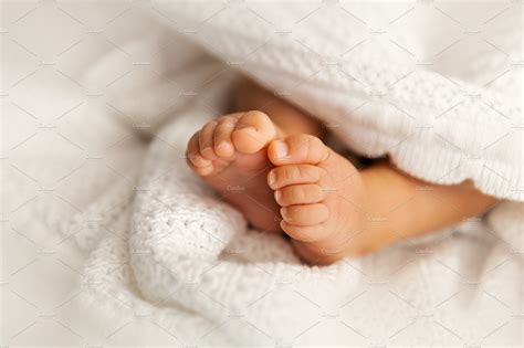 Newborn baby feet under blanket | People Images ~ Creative Market