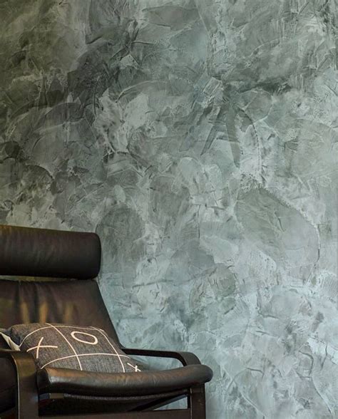 a leather chair sitting in front of a wall with a gray marble pattern on it