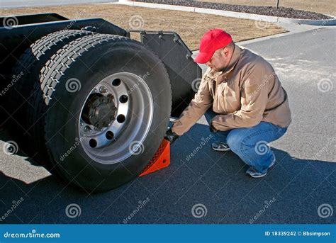 Young Male Truck Driver Chocking Wheels For Safety Stock Photography - Image: 18339242