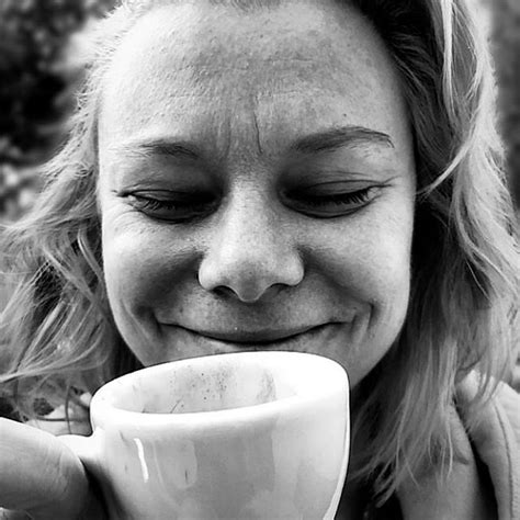 a black and white photo of a woman holding a coffee cup