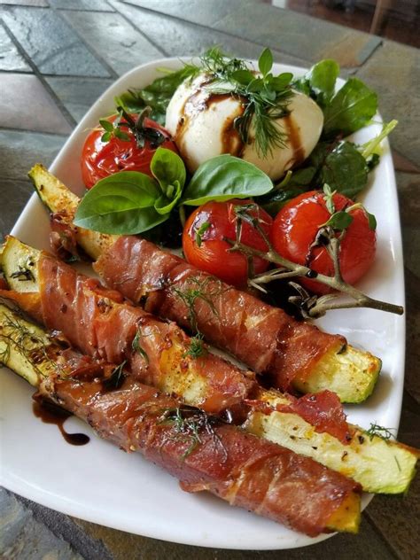 Roasted campari tomatoes and zucchini spears wrapped in prosciutto. With Burrata and fresh herbs ...