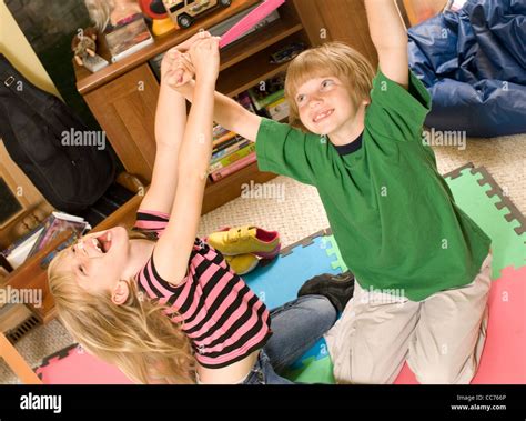 Twins wrestling and tickling in their playroom Stock Photo - Alamy