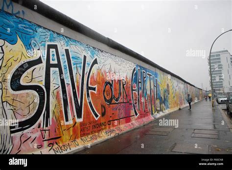 The Berlin Wall at the East Side Gallery, "Save Our Earth" graffiti ...