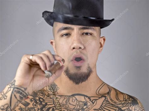 Man with body tattoo smoking cigar — Stock Photo © kozzi2 #17434809