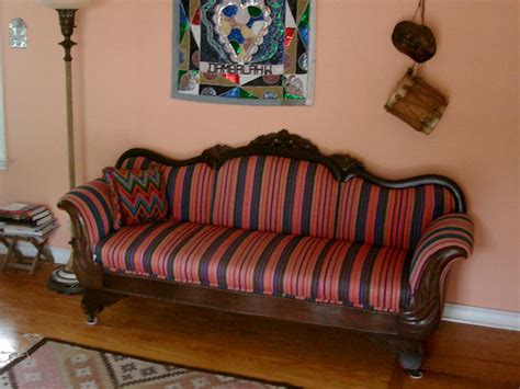 This antique, Victorian-style couch has been re-upholstered with colorful, striped, hand-woven ...