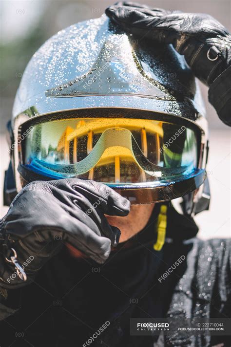 Firefighter poses with helmet looking at camera. — help, truck - Stock ...