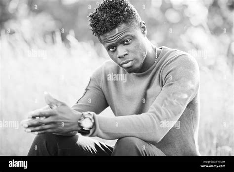 Cool black african american man sitting and posing on railway in the countryside Stock Photo - Alamy