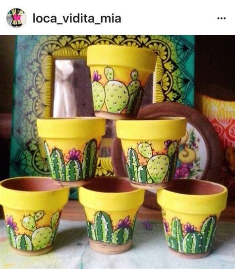 yellow flower pots with cactus designs painted on them