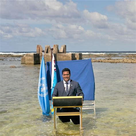 A minister of Tuvalu gives speech in water where land once was to show ...