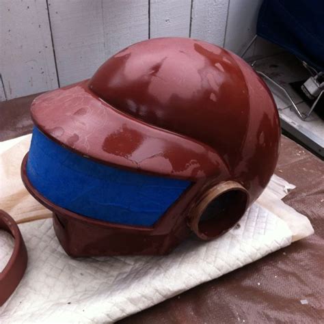 a brown and blue helmet sitting on top of a table next to a pair of scissors