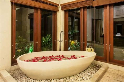 a large bathtub with red flowers in it