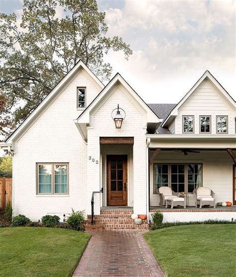 a white house with brick walkway leading to the front door