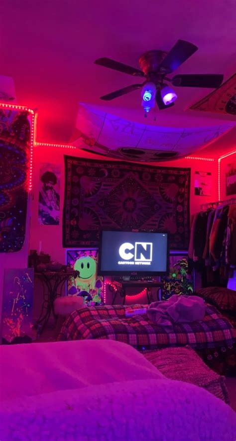 the room is lit up with neon lights and decorations on the walls, along with a flat screen tv